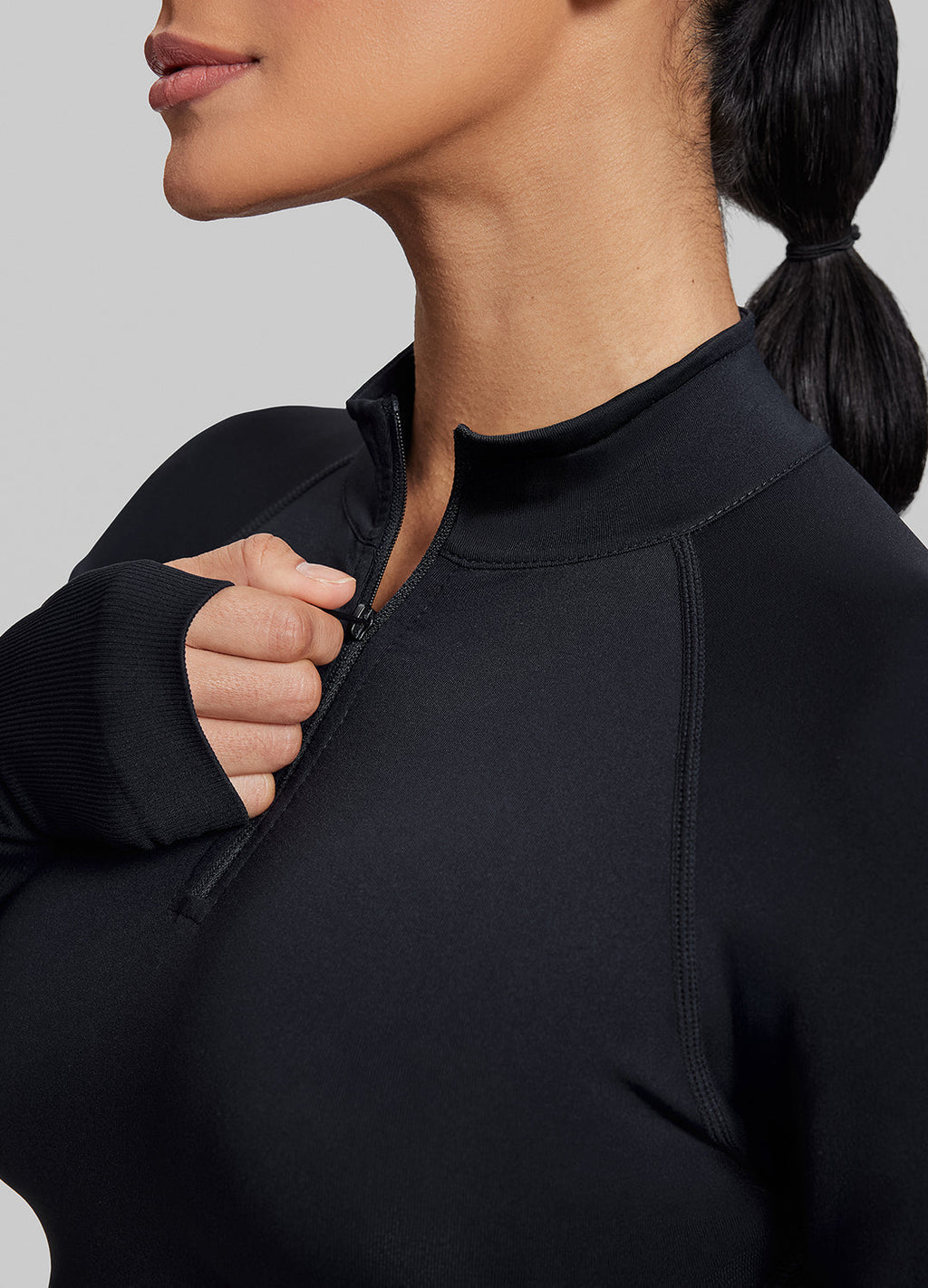 Haut ajusté sans coutures en tricot sergé avec demi-fermeture éclair et trous pour les pouces, coupe longue