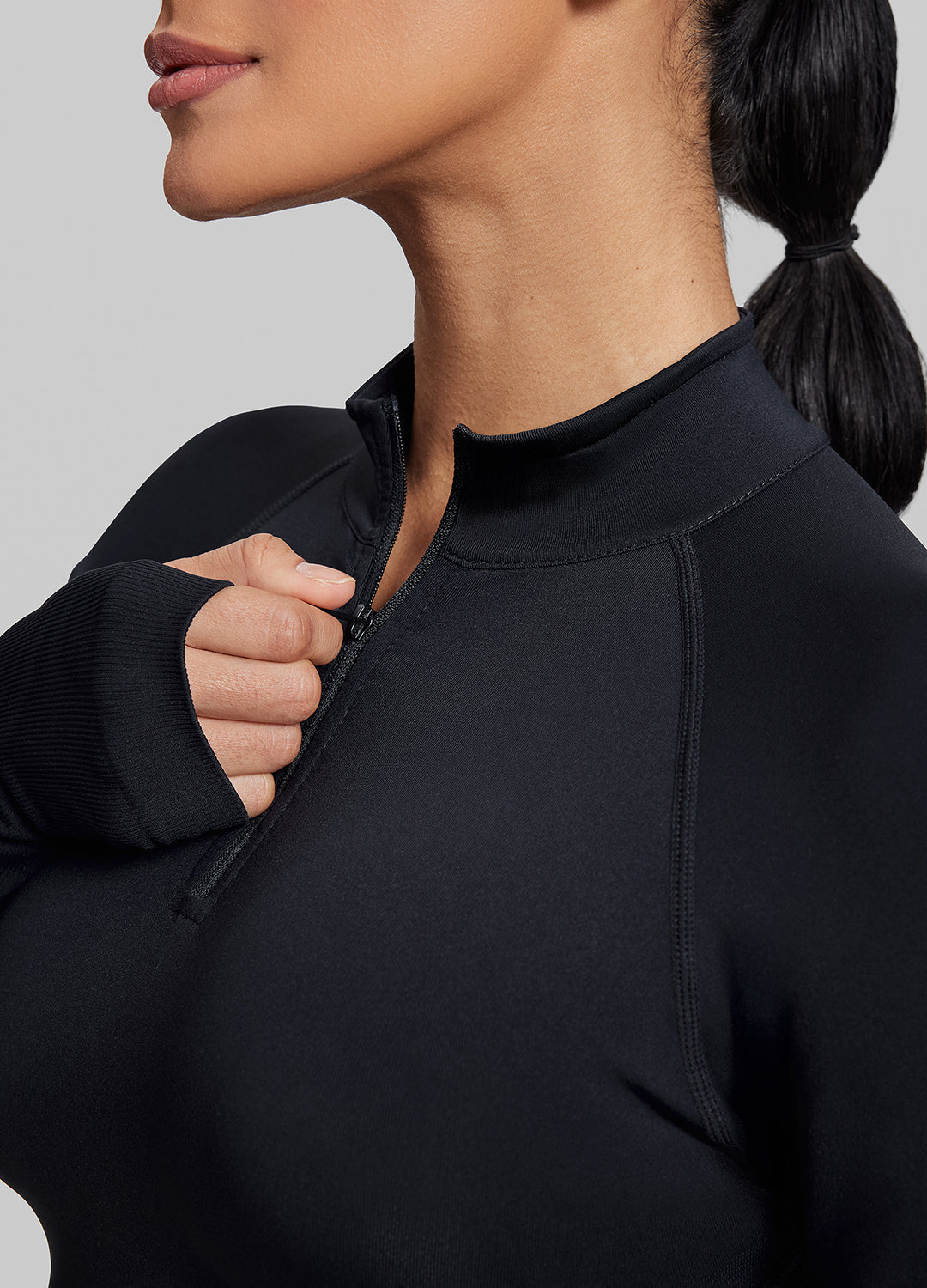 Haut ajusté sans coutures en tricot sergé avec demi-fermeture éclair et trous pour les pouces, coupe longue