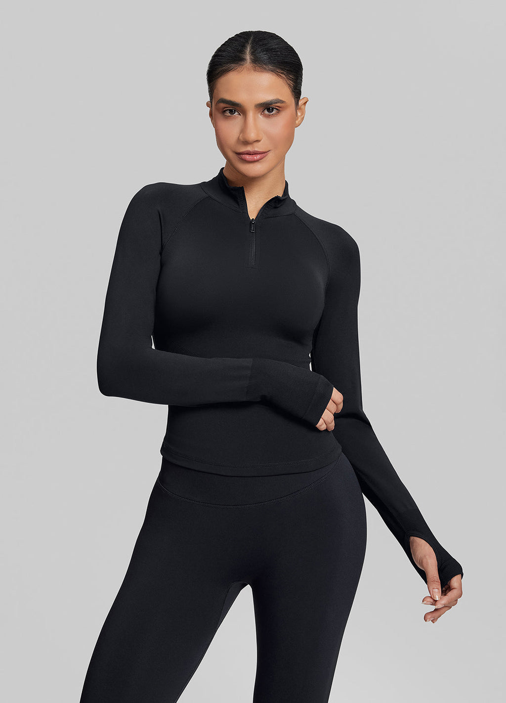 Haut ajusté sans coutures en tricot sergé avec demi-fermeture éclair et trous pour les pouces, coupe longue