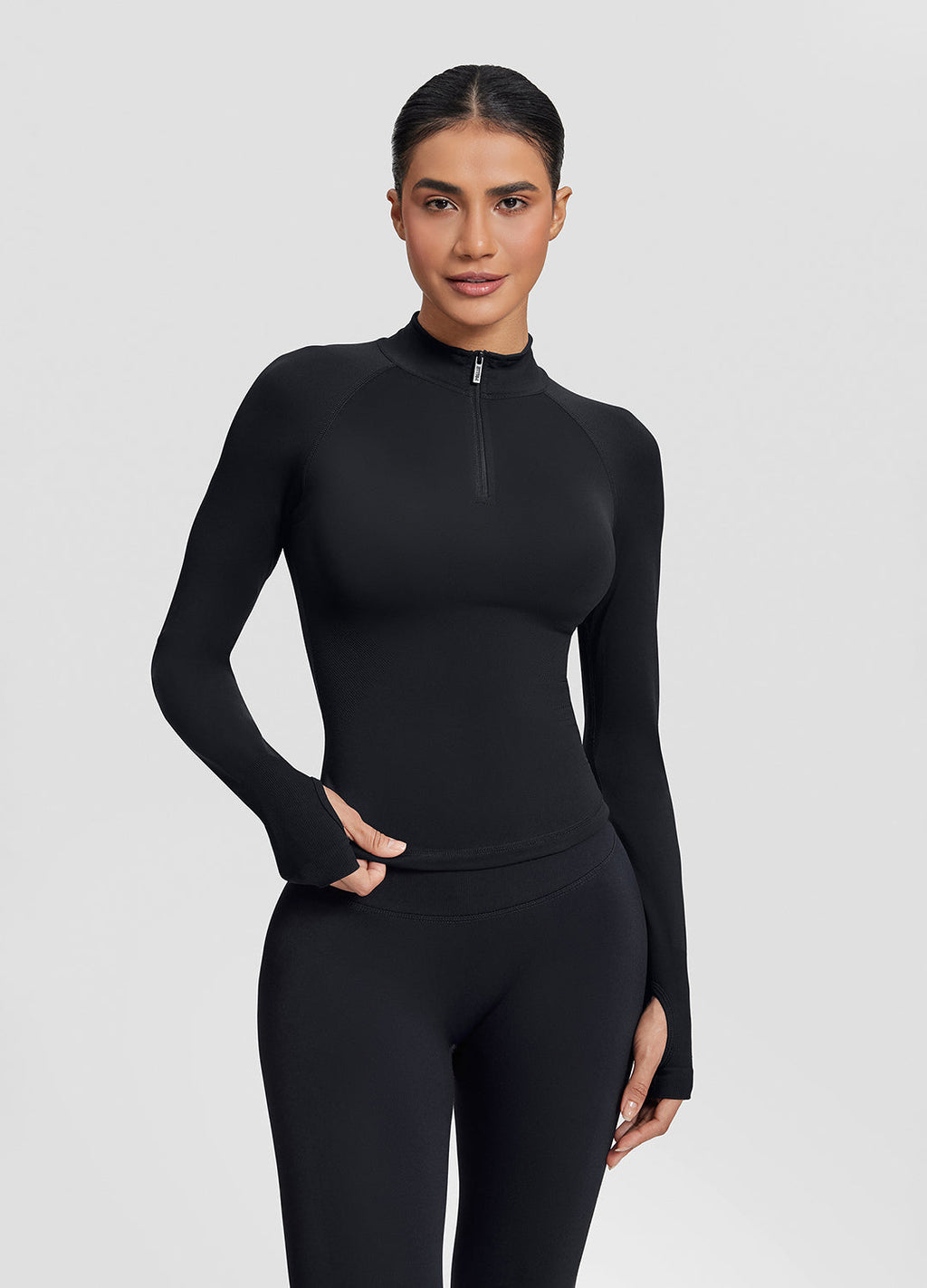Haut ajusté sans coutures en tricot sergé avec demi-fermeture éclair et trous pour les pouces, coupe longue