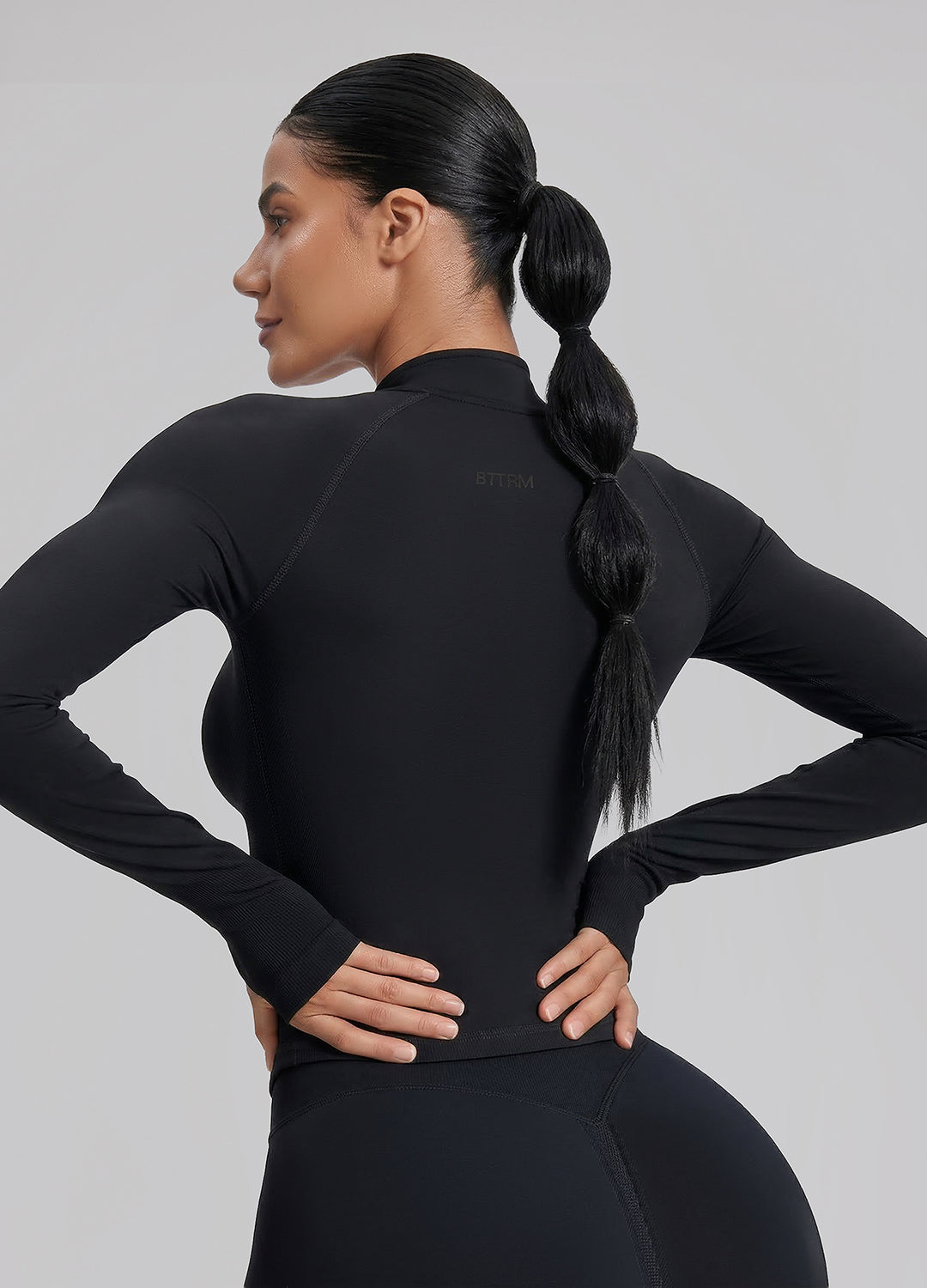 Haut ajusté sans coutures en tricot sergé avec demi-fermeture éclair et trous pour les pouces, coupe longue