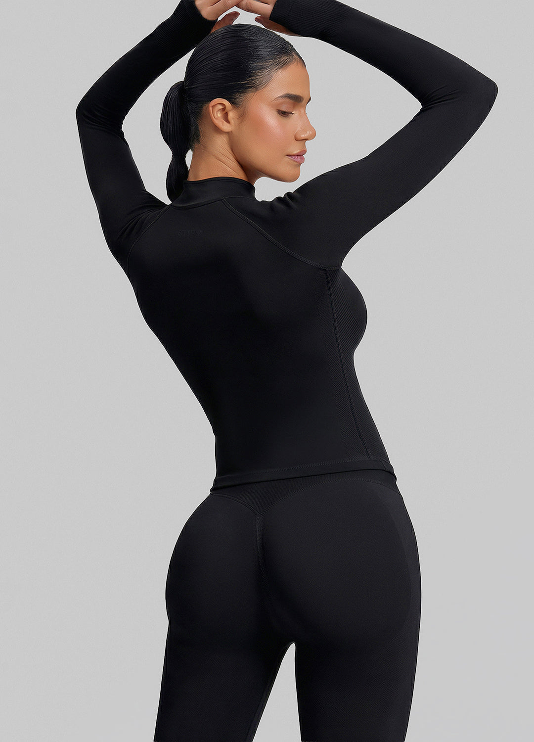 Haut ajusté sans coutures en tricot sergé avec demi-fermeture éclair et trous pour les pouces, coupe longue